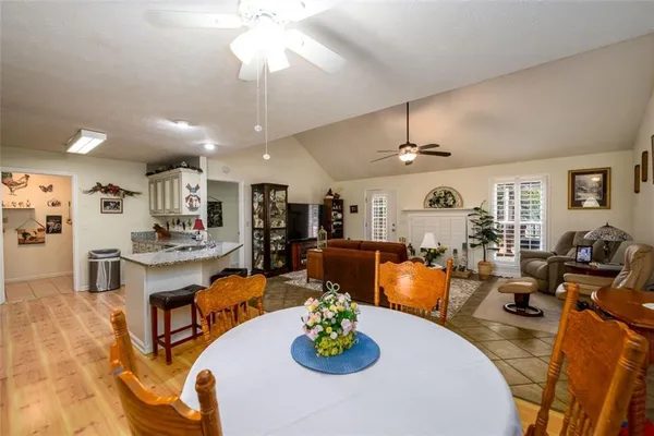 a living room with furniture kitchen view and a chandelier