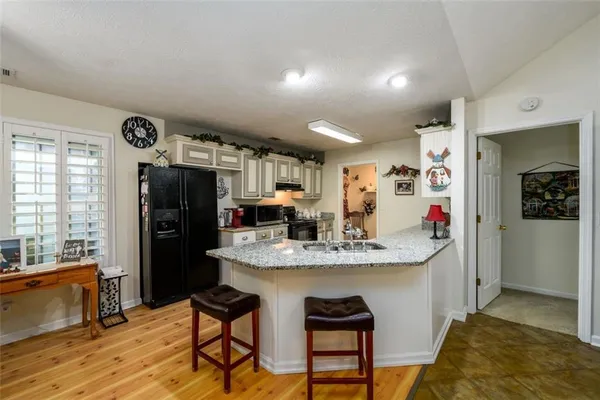 a kitchen with stainless steel appliances granite countertop a refrigerator and a stove top oven