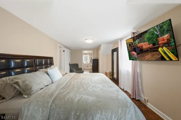 a spacious bedroom with a bed and a flat screen tv