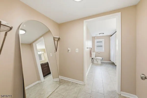 a view of a hallway with wooden floor and a living room