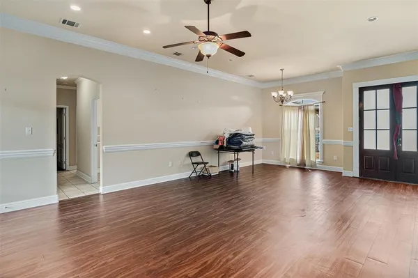 a view of a livingroom with furniture a ceiling fan and hardwood floor