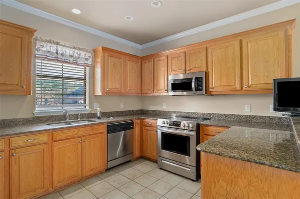 a kitchen with granite countertop a sink stove and microwave