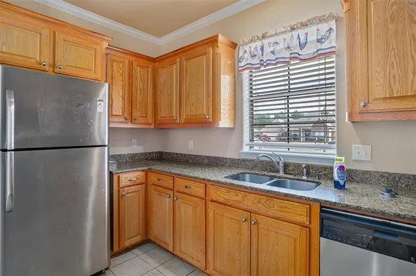 a kitchen with stainless steel appliances granite countertop a sink and a refrigerator
