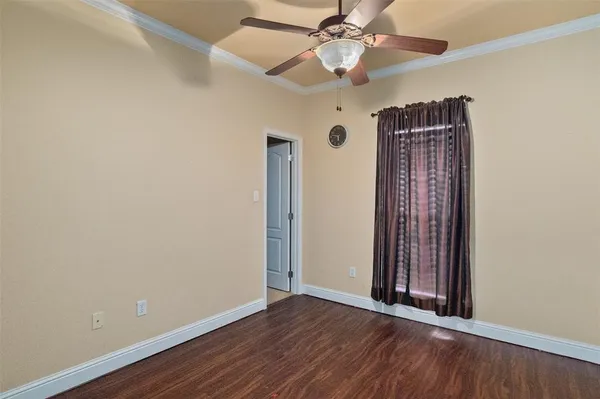 an empty room with wooden floor chandelier fan and closet area