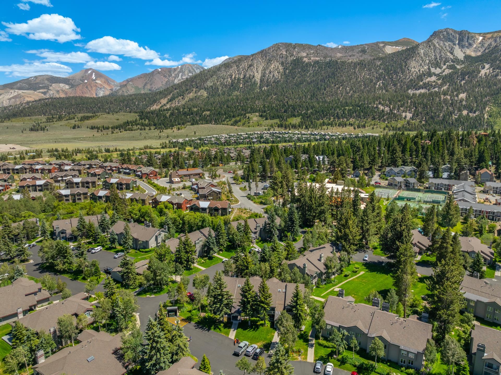 609 Golden Creek Road, Unit 609 Mammoth Lakes, CA 93546 - Photo 41 of 42 Expansive community featuring multiple residential buildings, abundant mature trees, paved roadways, and a visible tennis court