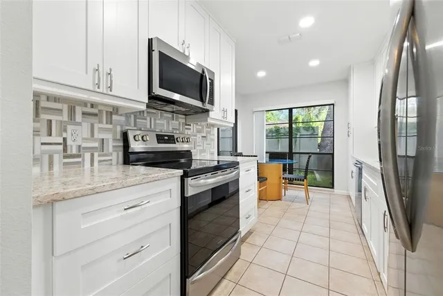 a kitchen with stainless steel appliances kitchen island granite countertop a stove a sink and a microwave