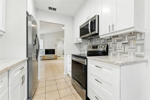 a kitchen with stainless steel appliances granite countertop a sink and a stove