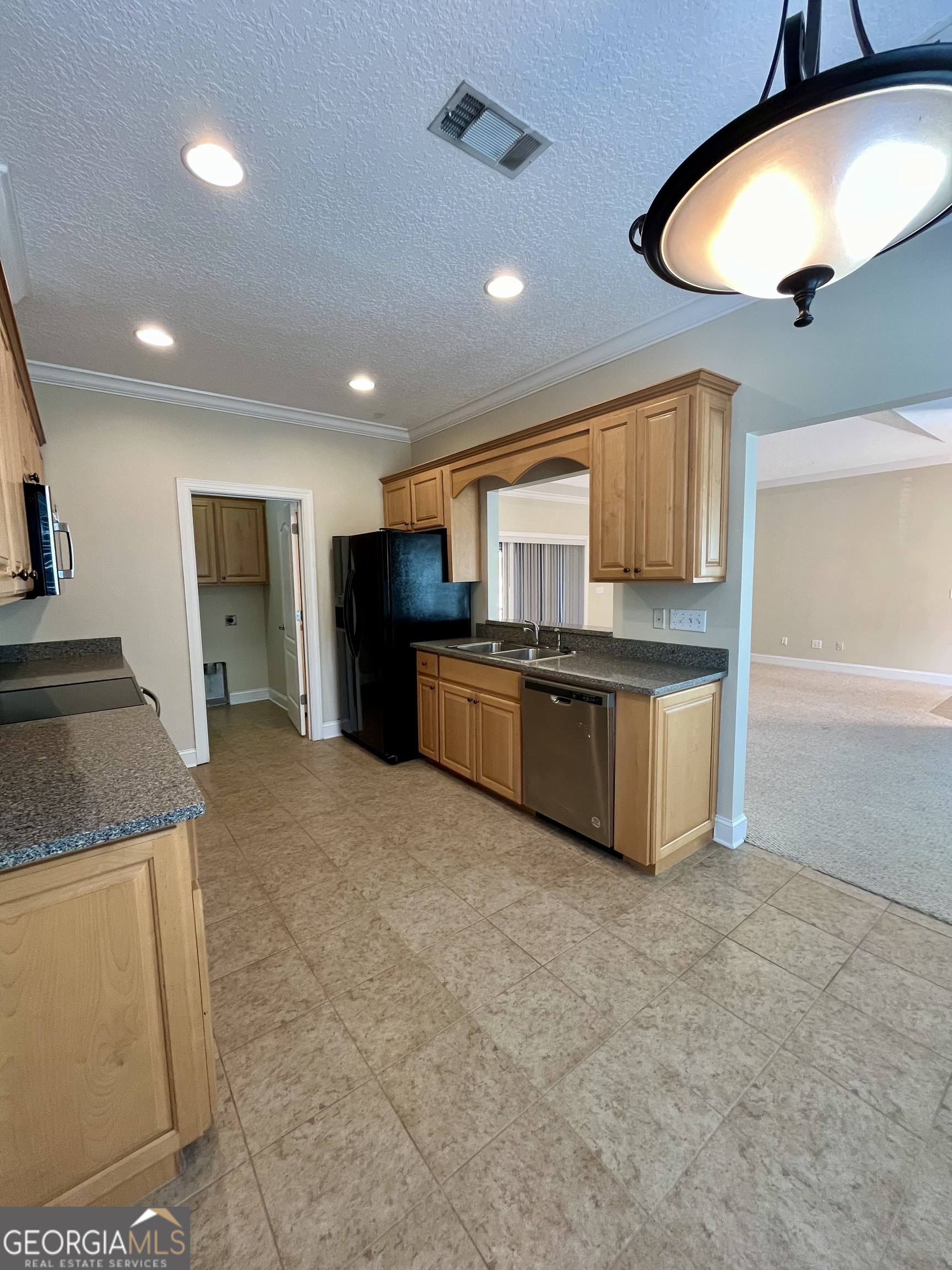 49 Coastal Walk St. Marys, GA 31558 - Photo 11 of 42 a kitchen with stainless steel appliances granite countertop a sink and a refrigerator