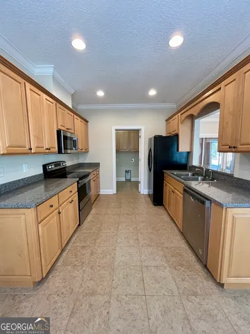 a large kitchen with stainless steel appliances granite countertop a stove top oven a sink dishwasher a refrigerator and cabinets with wooden floor
