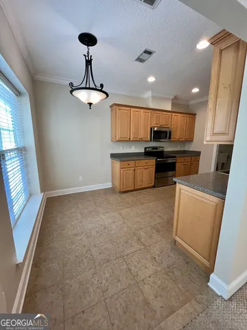 a kitchen with stainless steel appliances granite countertop a stove refrigerator and microwave