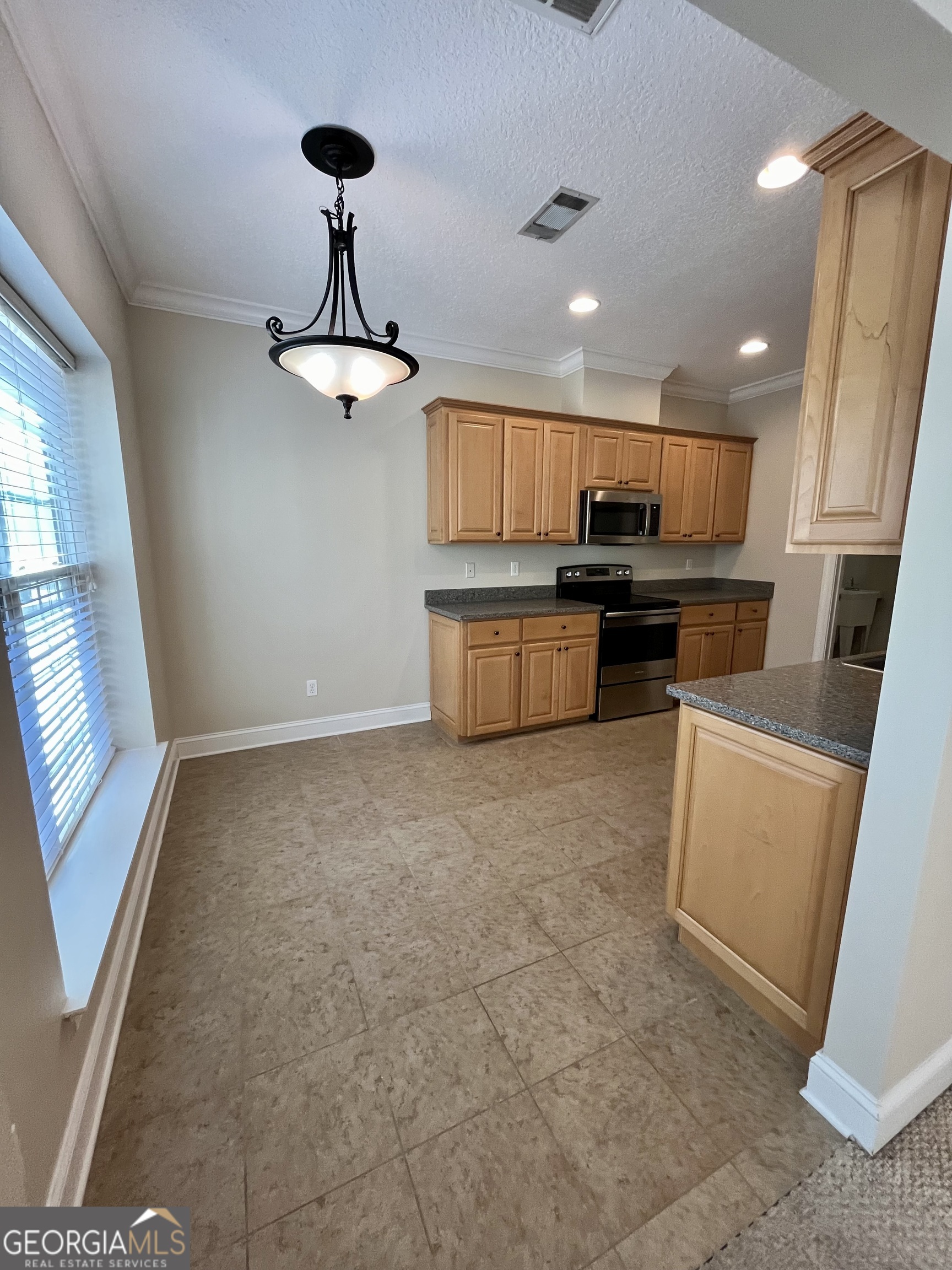 49 Coastal Walk St. Marys, GA 31558 - Photo 13 of 42 a kitchen with stainless steel appliances granite countertop a stove refrigerator and microwave