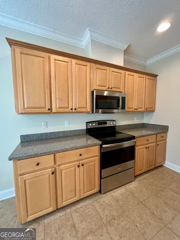 a kitchen with stainless steel appliances granite countertop a stove a sink dishwasher and a microwave oven on the blue kitchen countertops
