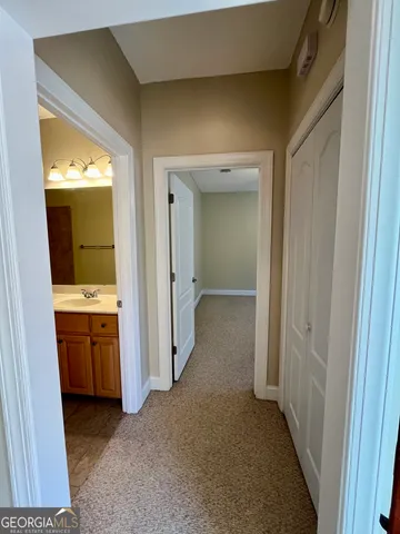 a view of hallway with sink and wooden floor