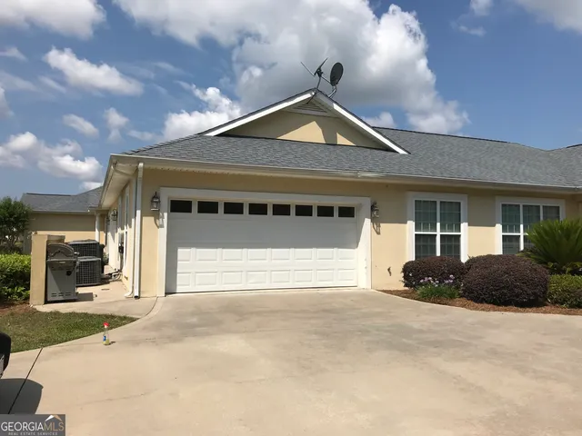 a front view of a house with a garden