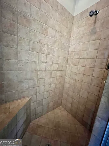 a spacious bathroom with a granite countertop sink a toilet and a mirror