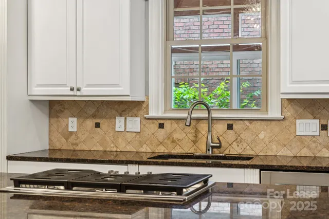 a kitchen with granite countertop a stove a sink and a granite counter tops