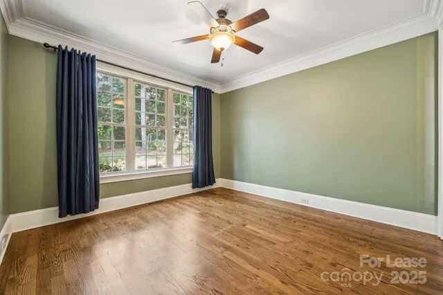 a view of a big room with windows and chandelier fan