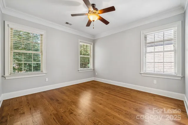 a view of empty room with ceiling fan and window