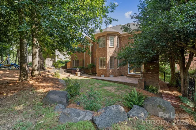 a view of a house with backyard and a tree