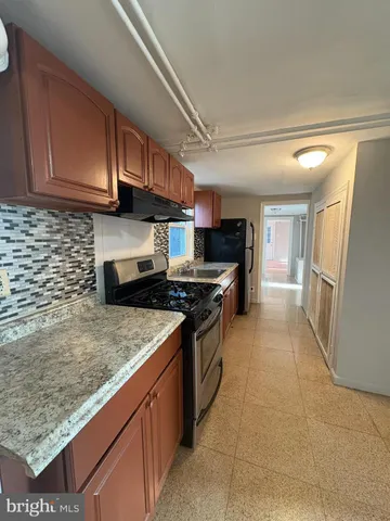 a kitchen with stainless steel appliances granite countertop a stove a refrigerator and a sink