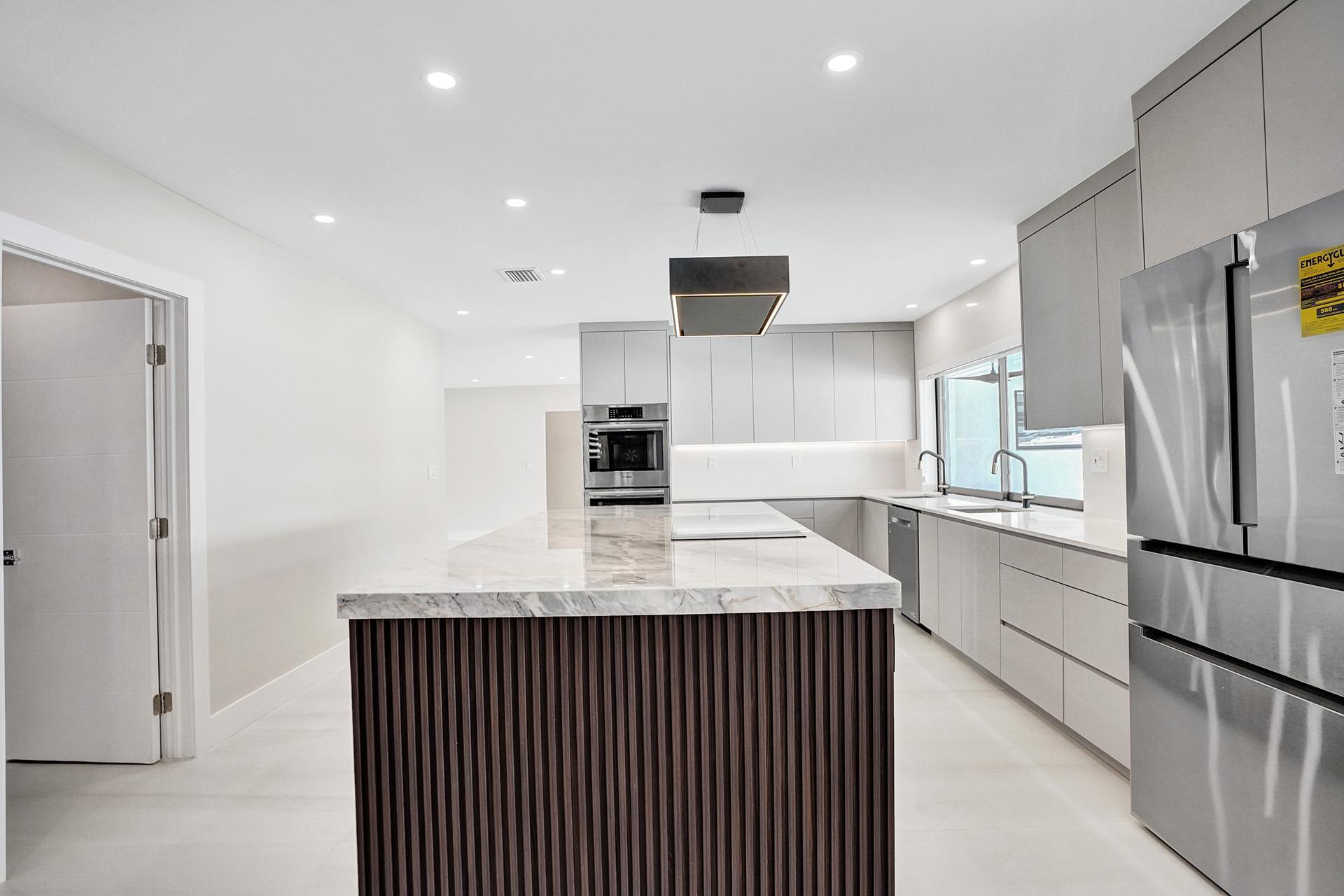 4951 Sarazen Drive Hollywood, FL 33021 - Photo 14 of 21 a kitchen with kitchen island granite countertop a refrigerator and a sink