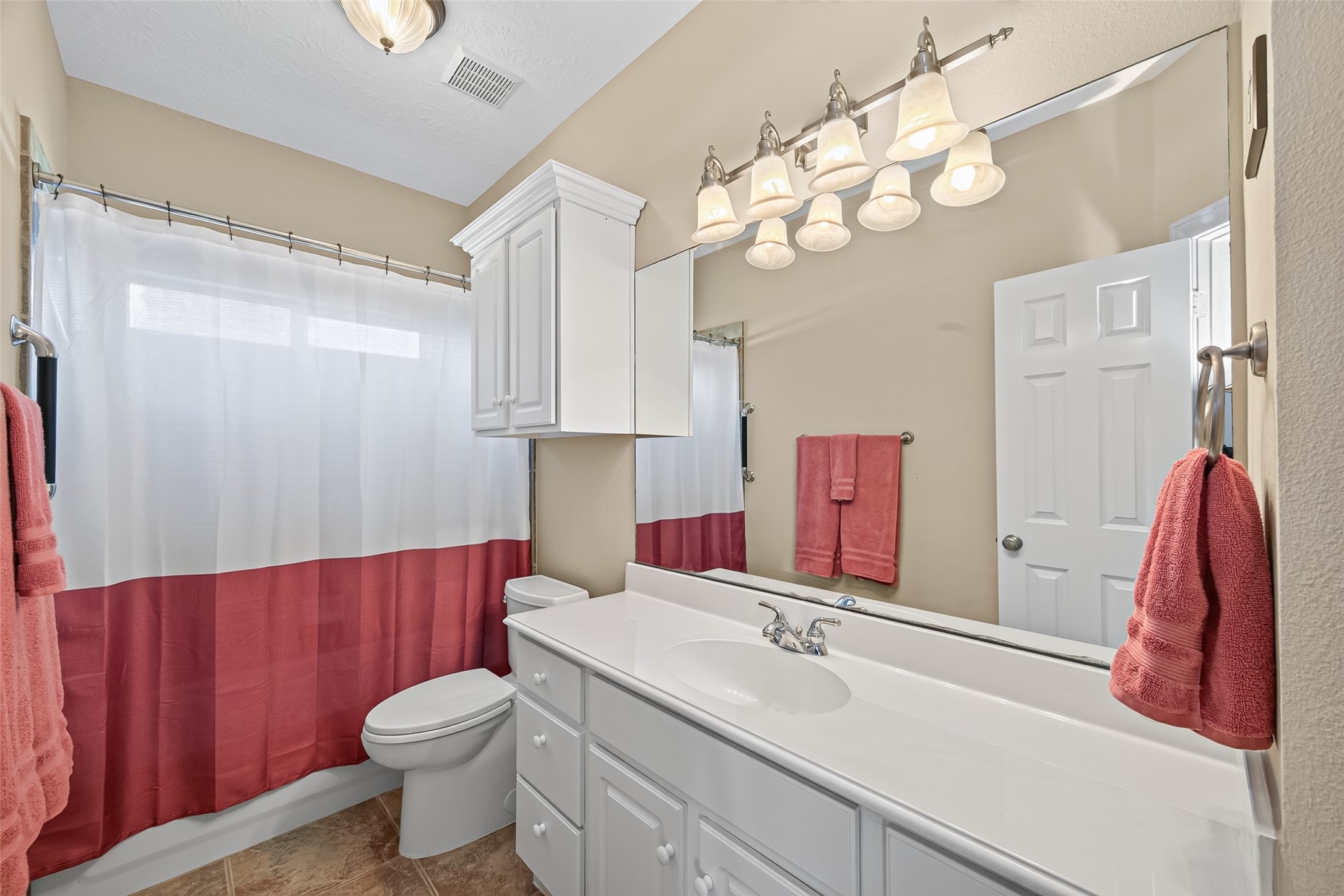 8114 Hideaway Run Way Spring, TX 77389 - Photo 21 of 37 Designed with convenience in mind, this functional bathroom showcases great lighting and a bath and shower combo, creating a bright and welcoming space for your daily routine. Generous counter space and ample storage provide both functionality and organization, offering plenty of room for toiletries, linens, and daily essentials.