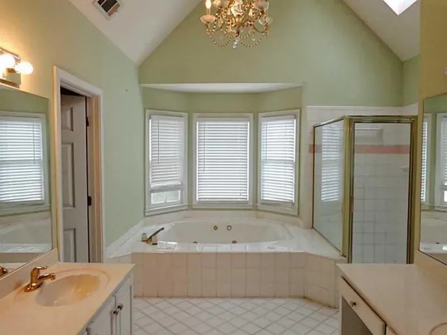 a bathroom with a tub sink and mirror