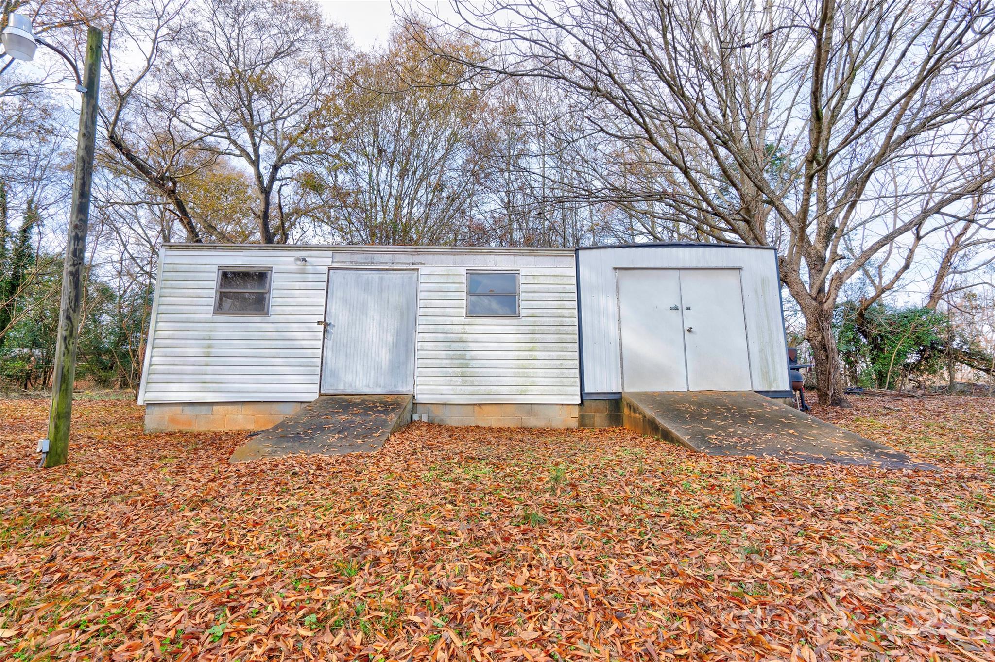 1602 Eaves Road Shelby, NC 28152 - Photo 18 of 19 a backyard of a house with large trees and covered with wooden fence