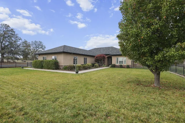 a kitchen with stainless steel appliances granite countertop a sink a stove and a wooden cabinets