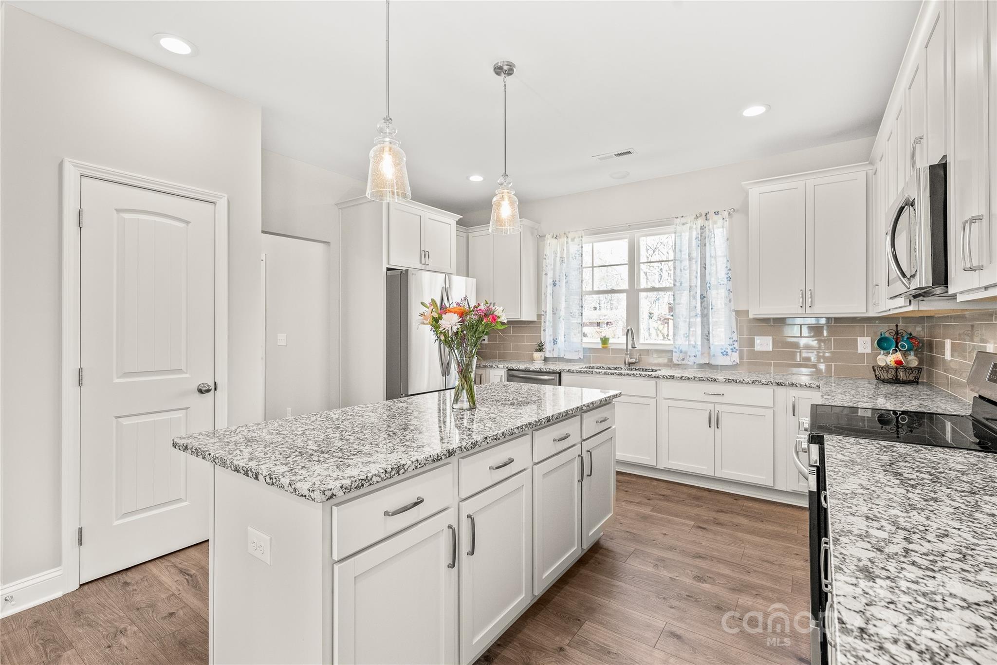 2116 Wilson Avenue Monroe, NC 28110 - Photo 6 of 21 a kitchen with granite countertop white cabinets and white appliances