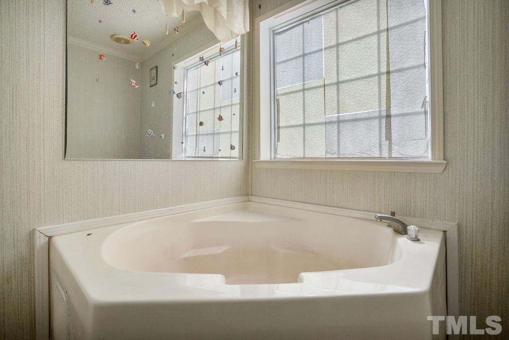 92 Wayland Drive St. Pauls, NC 28384 - Photo 20 of 36 a white bath tub sitting next to a window