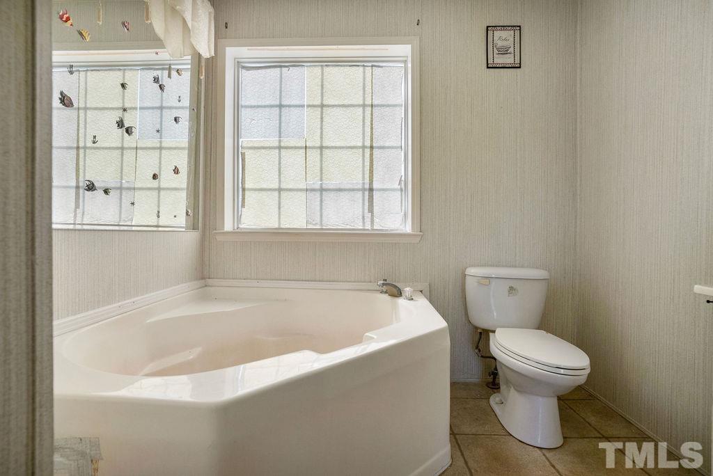 92 Wayland Drive St. Pauls, NC 28384 - Photo 21 of 36 a white bath tub sitting next to a toilet