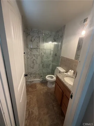 a bathroom with a granite countertop toilet and a sink
