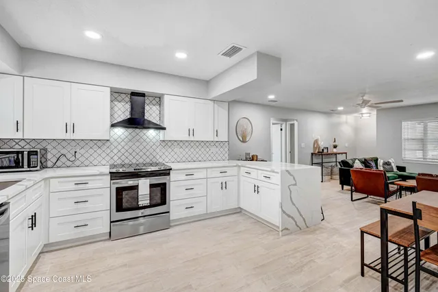 a kitchen with granite countertop white cabinets and stainless steel appliances