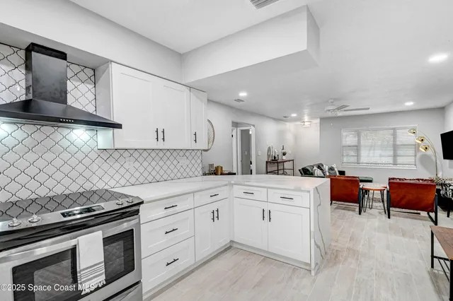 a kitchen with stainless steel appliances white cabinets and wooden floor