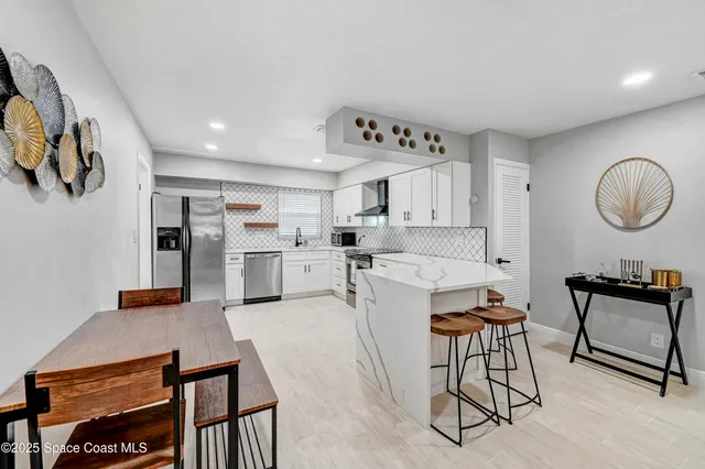 a living room with stainless steel appliances kitchen island furniture and a view of kitchen