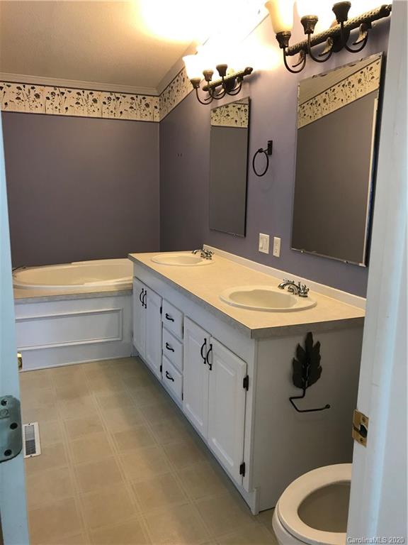 6431 Morgans Cove Road Monroe, NC 28110 - Photo 22 of 37 a bathroom with a sink a toilet and a mirror