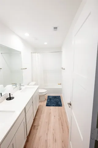 a spacious bathroom with a tub sink and mirror
