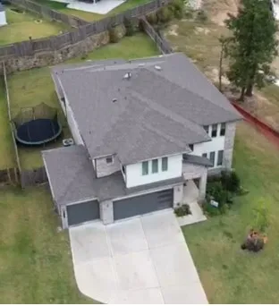 an aerial view of a house with a yard