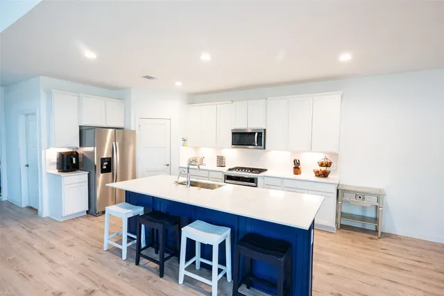 a kitchen with a dining table chairs refrigerator and cabinets