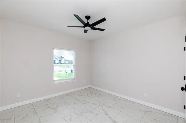 an empty room with a window and a fan