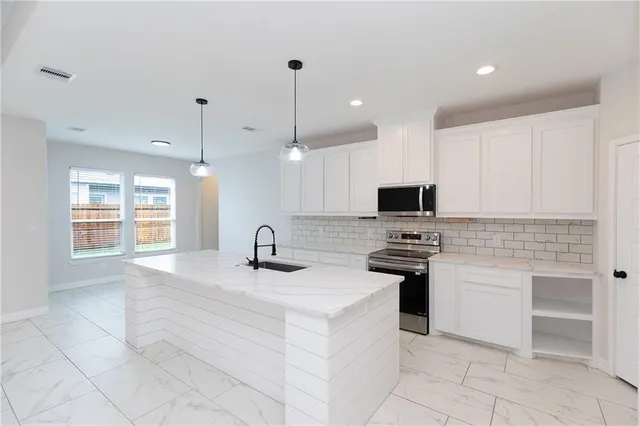 a kitchen with stainless steel appliances granite countertop a sink and a stove