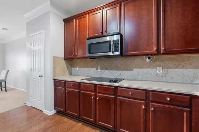 a kitchen with granite countertop wooden cabinets a sink and stainless steel appliances