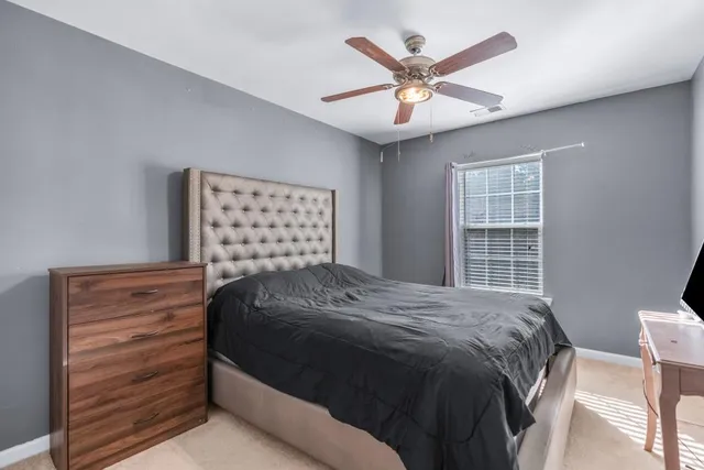 a bedroom with a large bed chandelier and a window