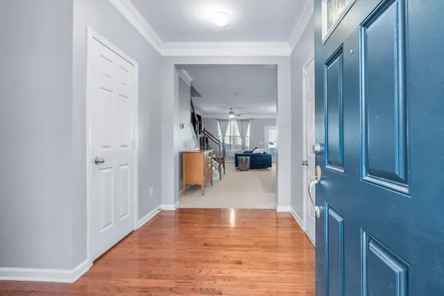 a view of a hallway view with wooden floor and a bathroom