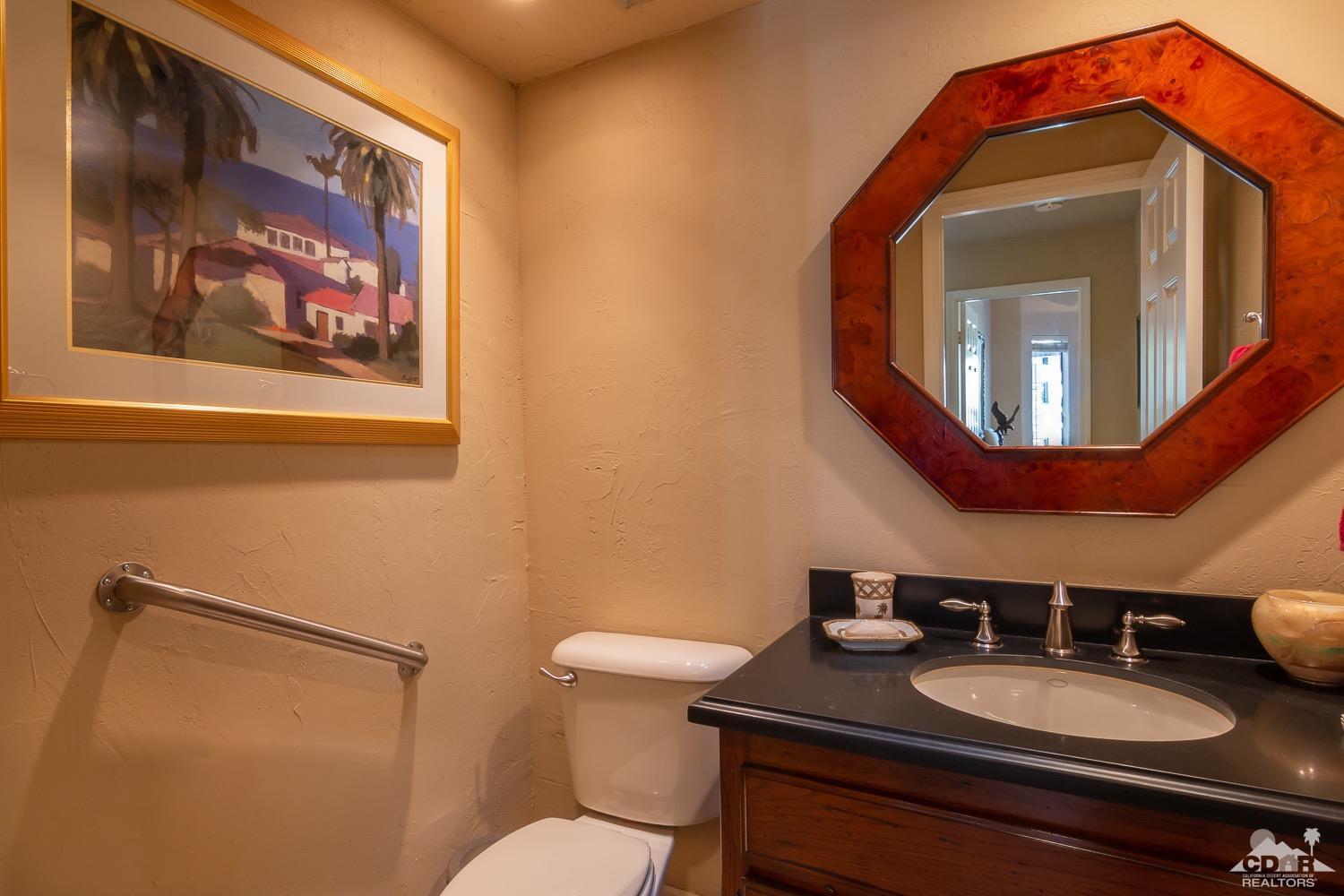 353 Red River Road Palm Desert, CA 92211 - Photo 16 of 28 a bathroom with a toilet a sink and mirror