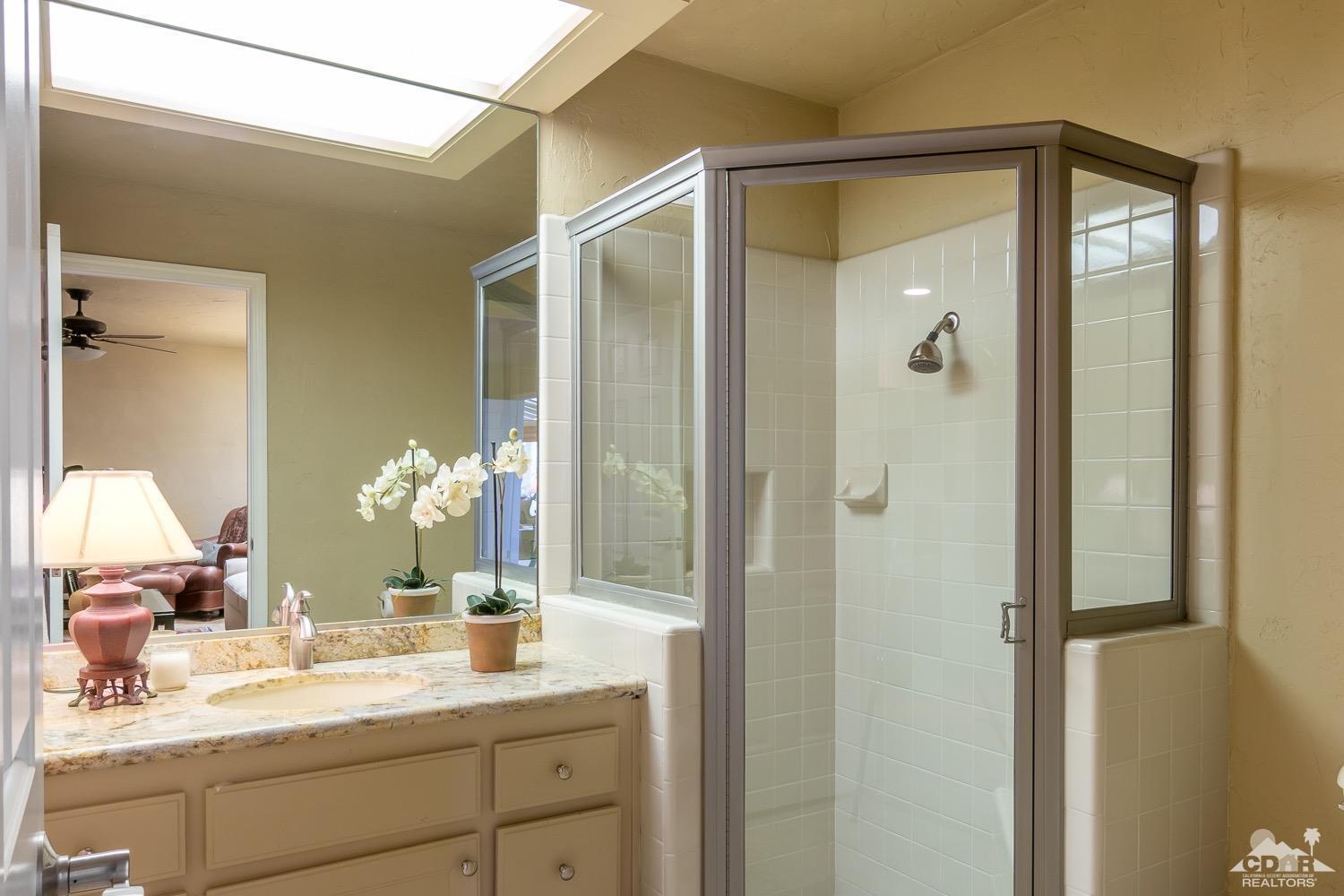 353 Red River Road Palm Desert, CA 92211 - Photo 18 of 28 a en suite bathroom with a granite countertop sink and a mirror