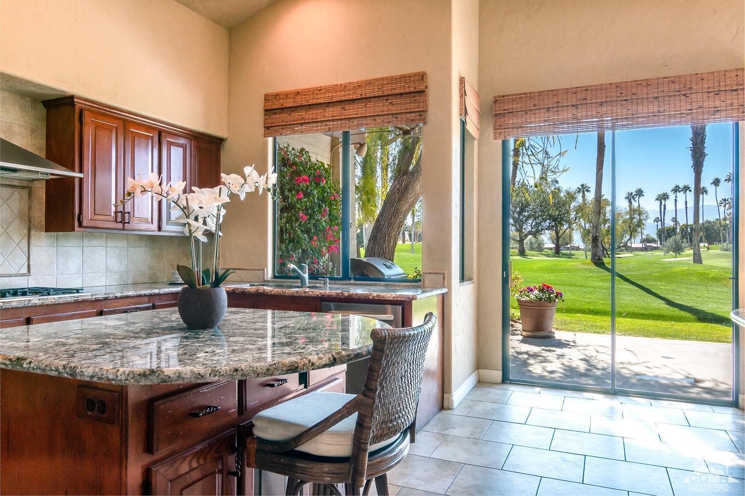 353 Red River Road Palm Desert, CA 92211 - Photo 7 of 28 a kitchen with granite countertop a table chairs and a stove
