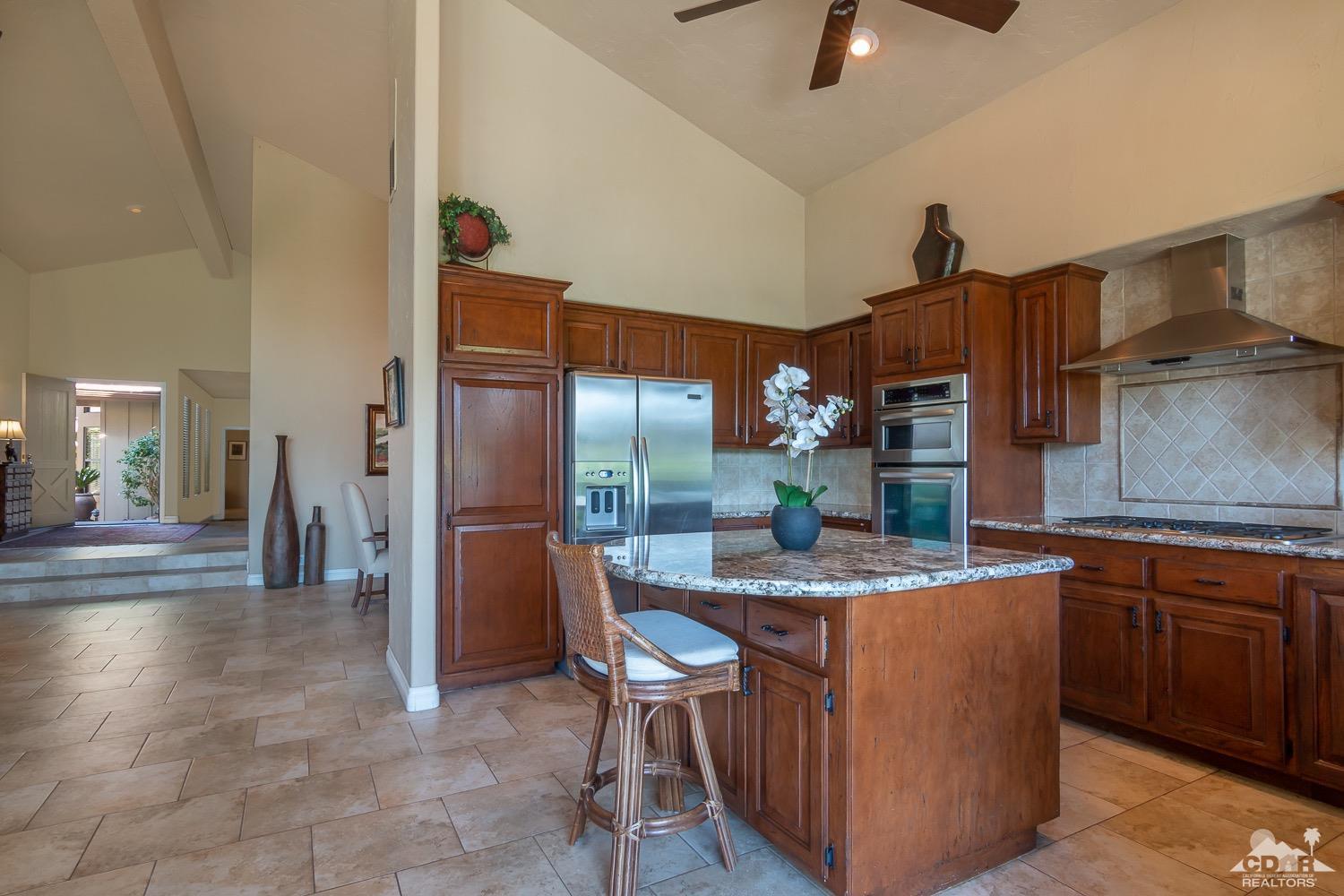 353 Red River Road Palm Desert, CA 92211 - Photo 9 of 28 a dining hall with stainless steel appliances granite countertop a table chairs and a refrigerator