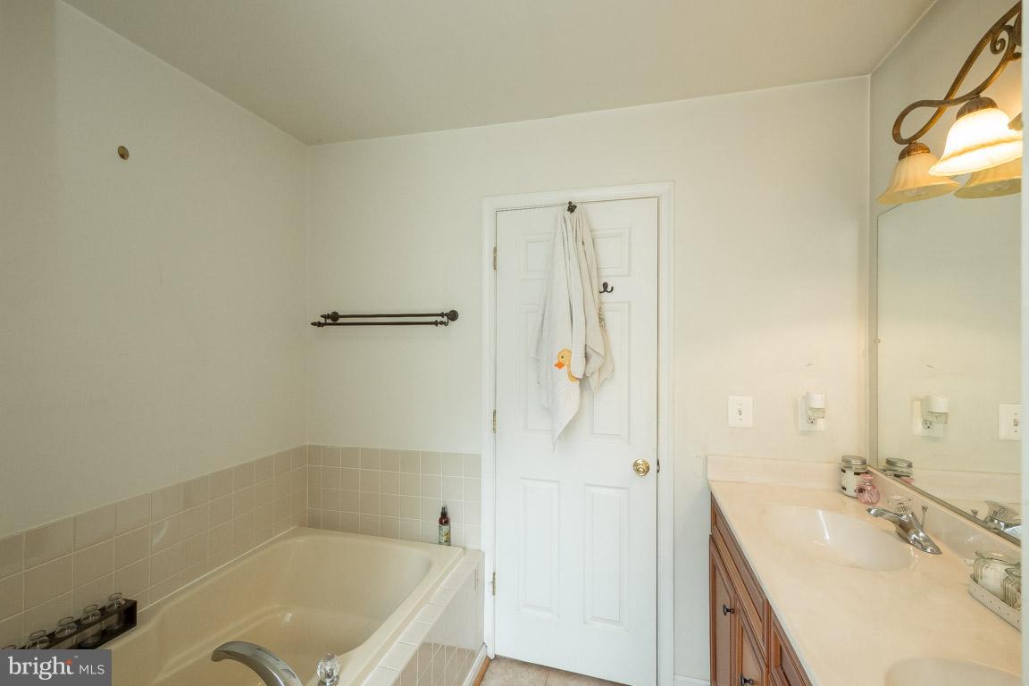 8339 Kines Road Warrenton, VA 20187 - Photo 17 of 19 a bathroom with a tub sink vanity granite and shower